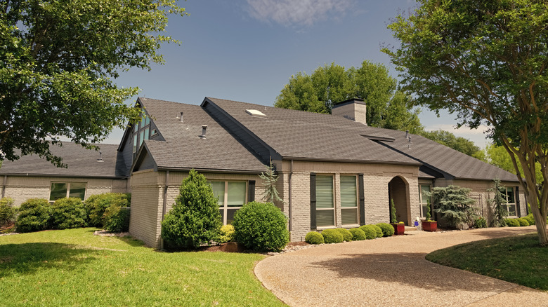 House with little space for a porch, driveway and trees