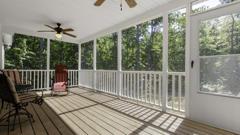 Screened in porch with chairs and fans