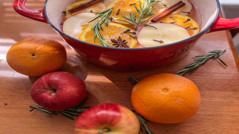 Red pot filled with fruit slices and herbs for simmering