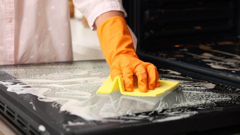 Person cleaning oven