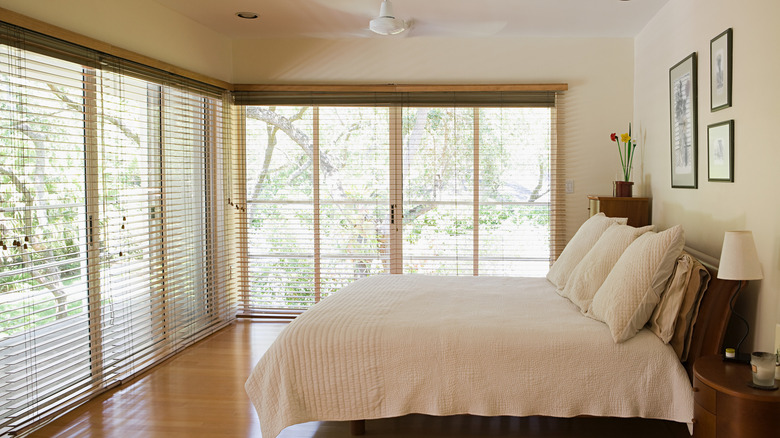 Bedroom with two walls of windows, each covered with a set of blinds