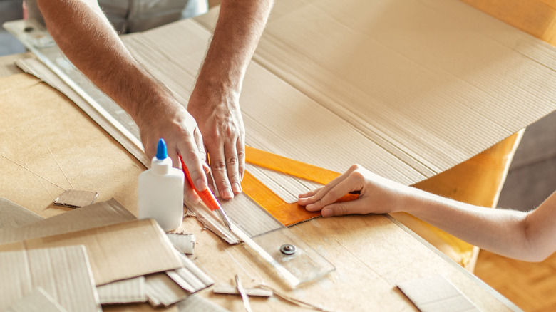 person measuring cardboard