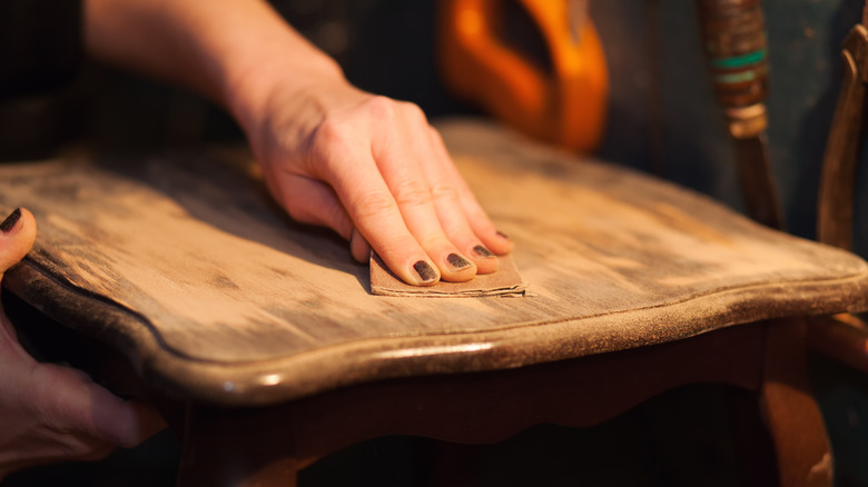 person's hand sanding table top