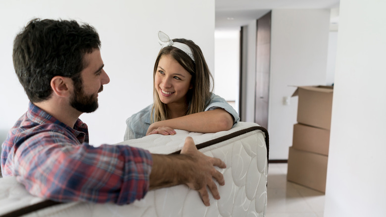 Man and woman moving mattress