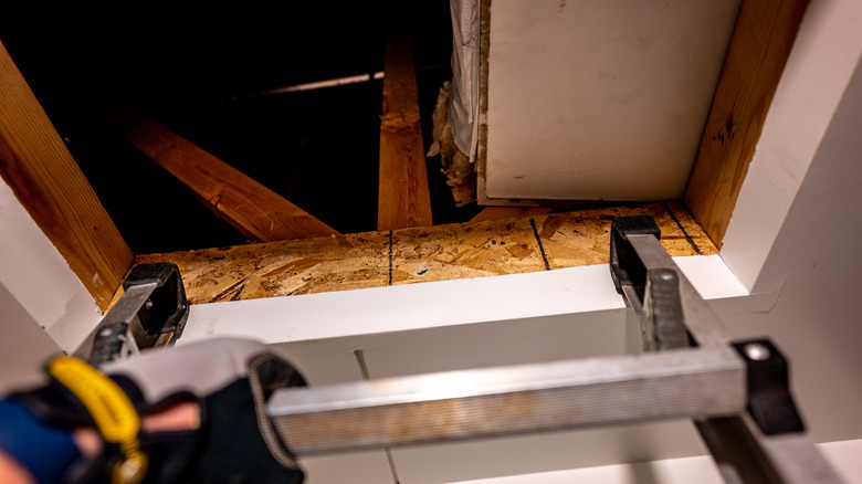 Attic ladder secured to opening