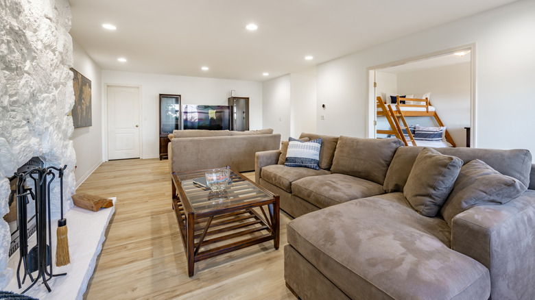 Gray sectional couch in living room with fireplace.