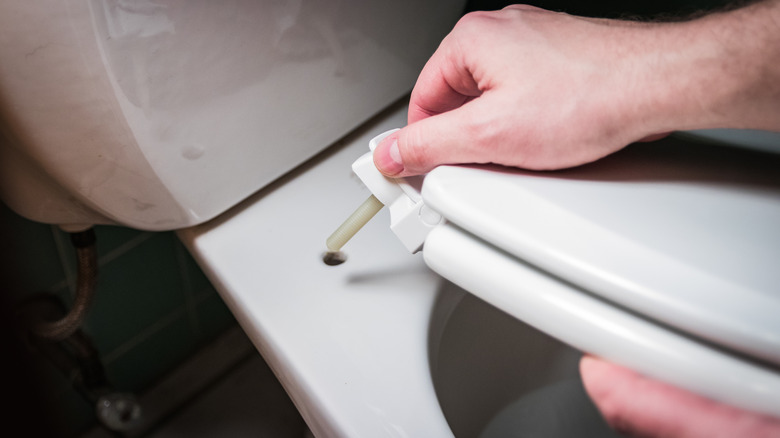 person installing toilet seat