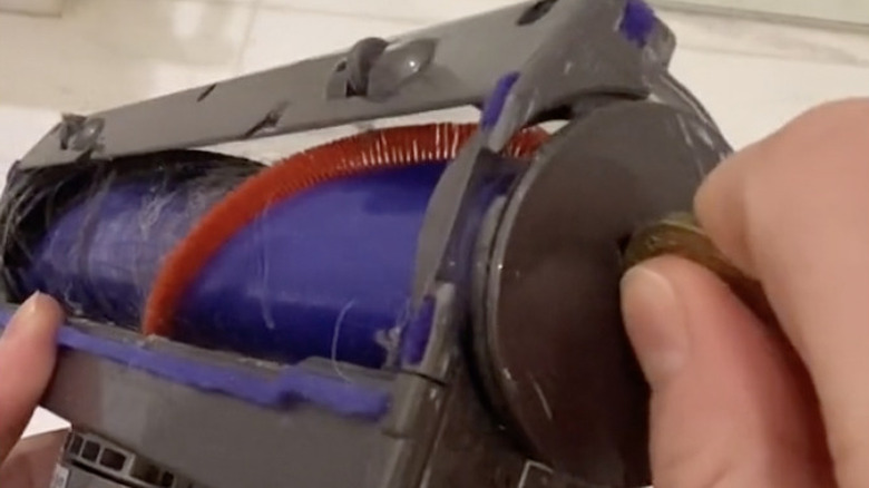 person inserting coin in Dyson vacuum 