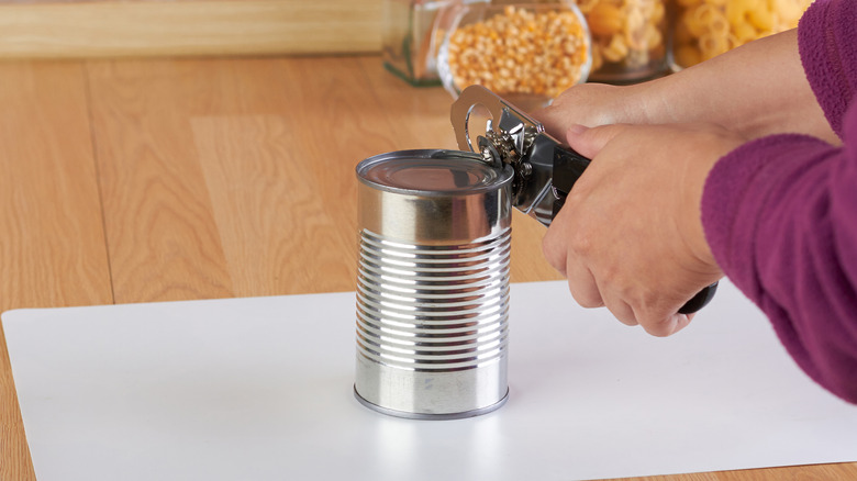 person using can opener