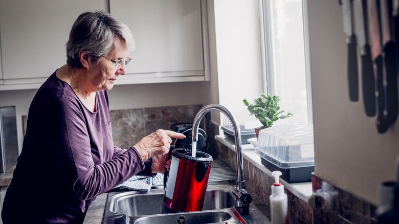 person cleaning electric kettle