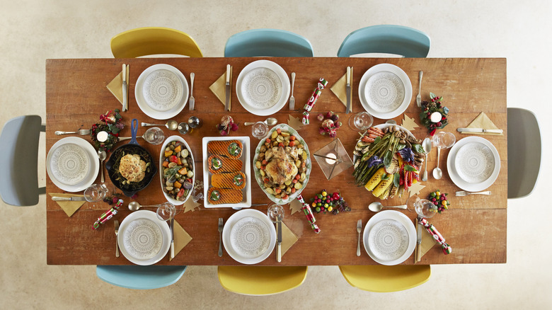 Plates and food sit on a decorated wooden dining table