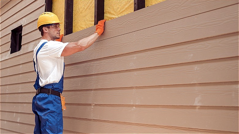 Person installing engineered wood siding