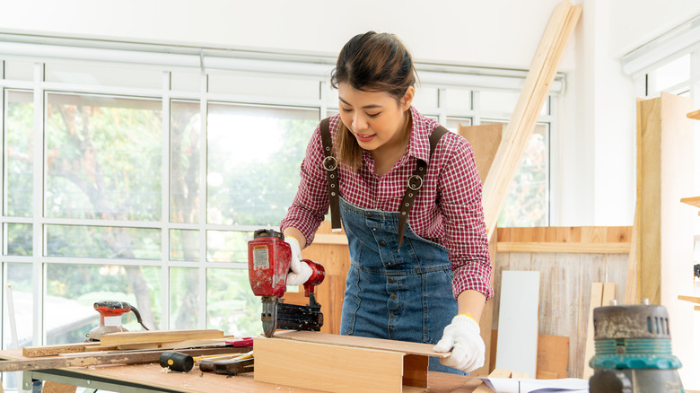 woman using red nail gun