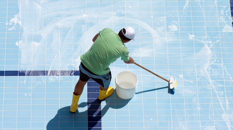 Man cleaning an empty pool