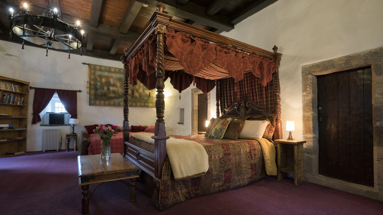 An ornate canopy bed is displayed at Chirk Castle