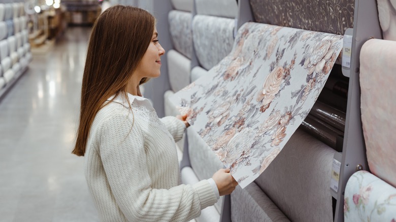 woman choosing wallpaper in store