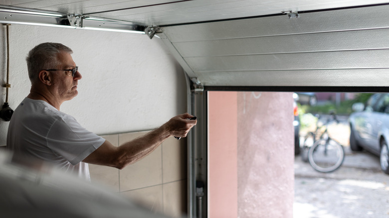 Man testing his garage door remote from inside garage