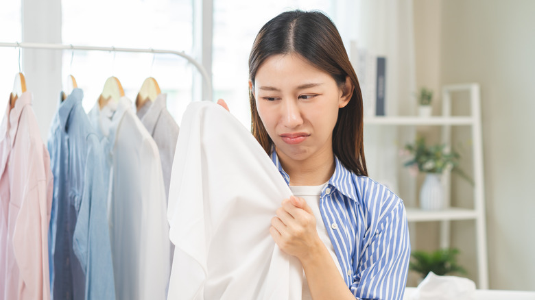 Woman staring at clothes and making a disgusted face