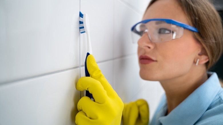 Woman scrubbing grout lines