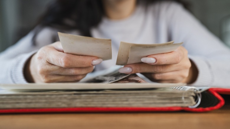 Woman looking at old photos in album