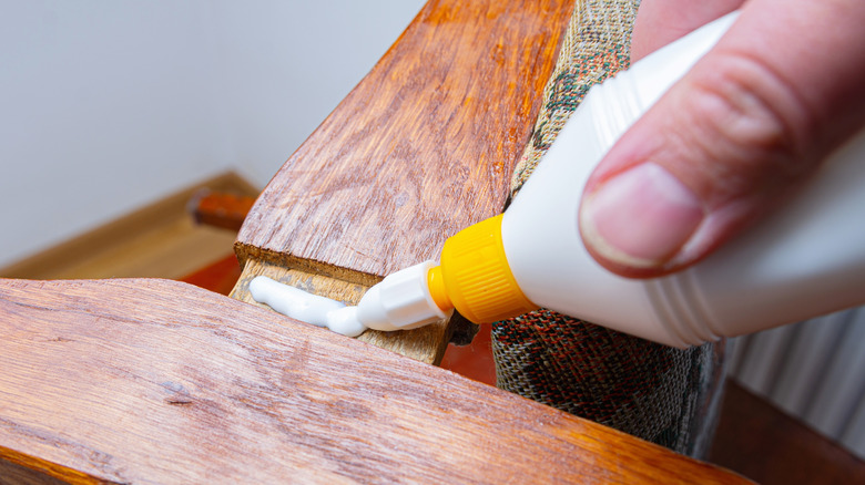 Person applying glue to wood