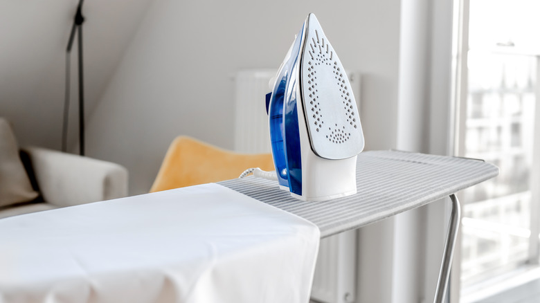 An iron resting on an ironing board